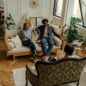 A couple in a counseling session with a therapist in a stylish, well-lit loft space.