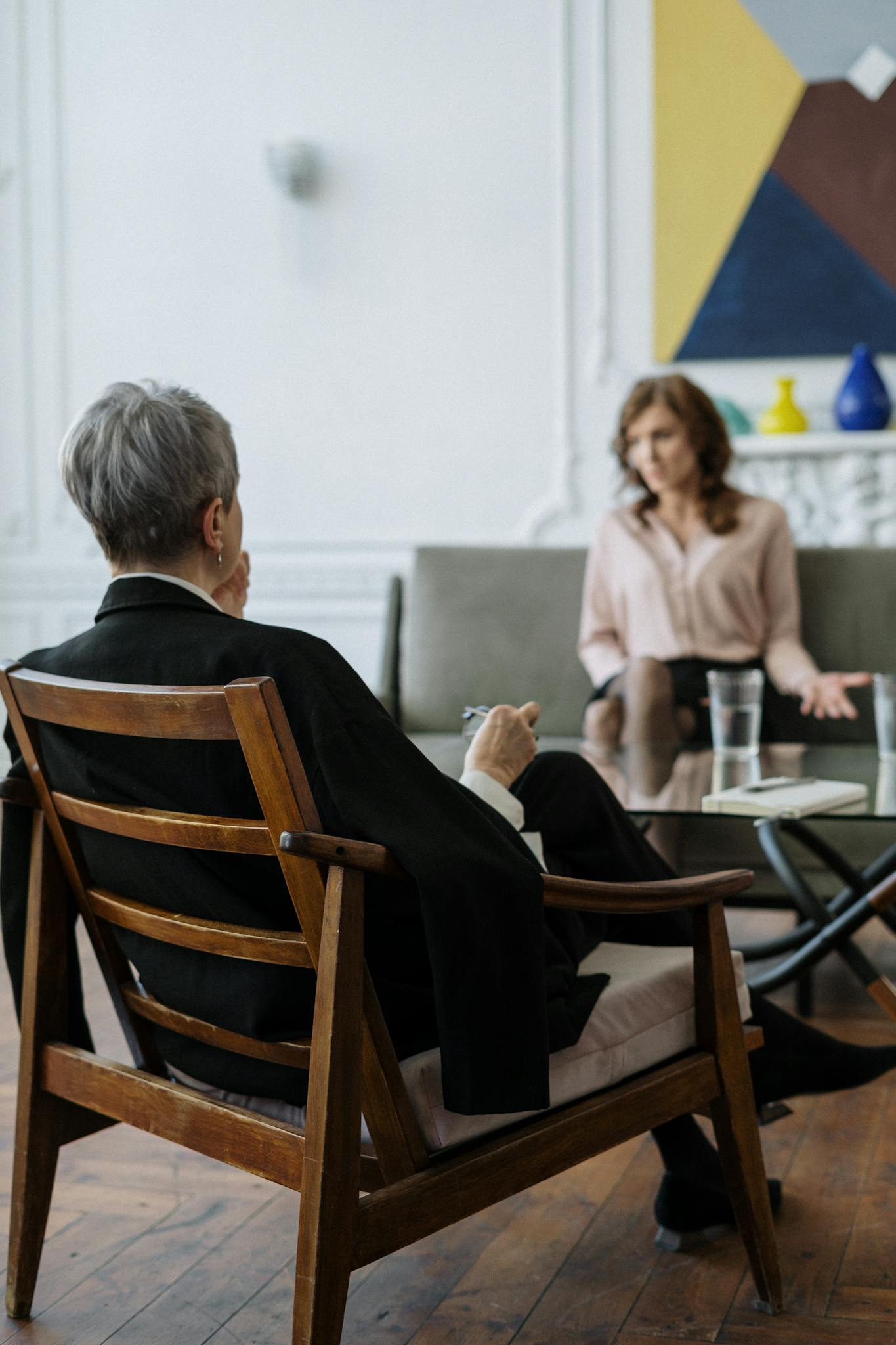 A therapist and patient engaged in a counseling session in a modern office setting.